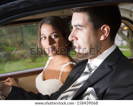 Married couple in a car. Man drives and woman is looking at him