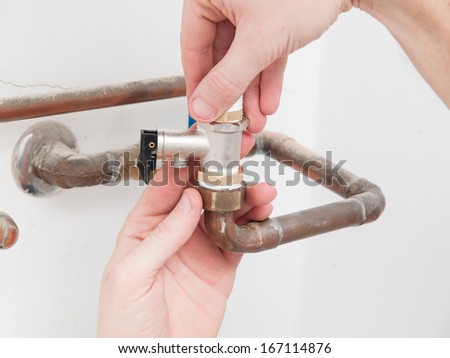 Man repairing a safety valve of an electric boiler