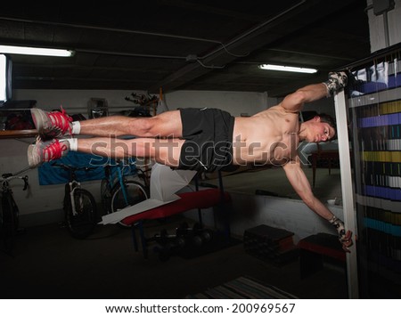 Man doing human flag exercise in a garage