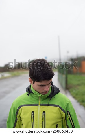 Young runner man portrait outdoors. Man is looking down and he has a copy space above