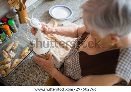 Elderly woman cooking in the kitchen at home