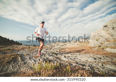 Man practicing trail running in a landscape of the coast
