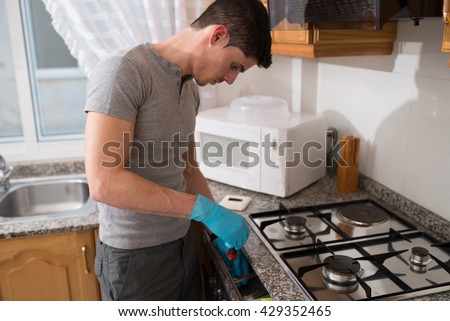 Man installing a gas hob in a kitchen.