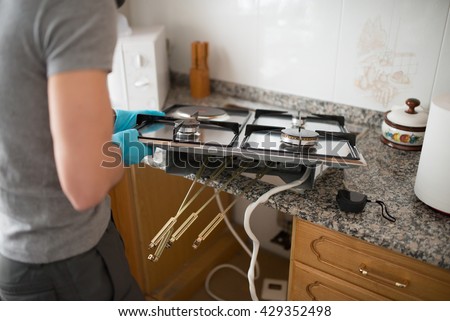 Man installing a gas hob in a kitchen.