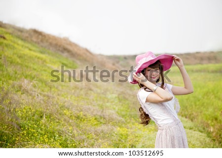 Asian female looking back with her had in wild flower field