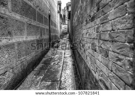 Alley way in an old town with ancient buildings under raining