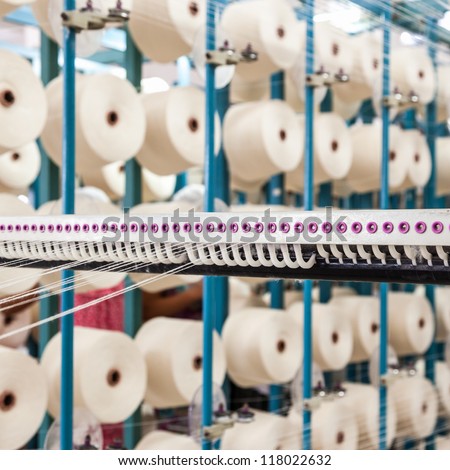 cotton threads coming from multiple small cotton cones and combined together in a yarn factory