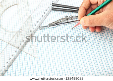 drawing compass , pencil, and ruler in the grid sheet studio shoot