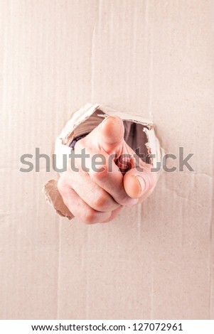 angry fist break through cardboard