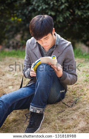 asian male student studying in the park