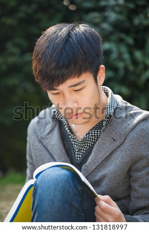 asian male student studying in the park