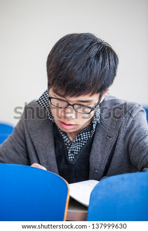 asian chinese male student studying in classroom