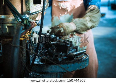 lathe machine in a car spare parts work shop, worker working with the machine