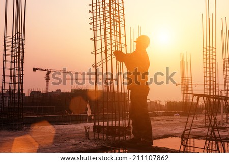 worker working with concrete iron near sunset worker working with concrete iron near sunset