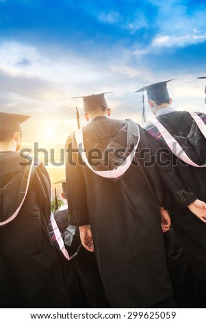 back view of college students with cap and gown celebrate graduation