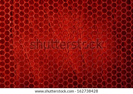 Openwork mesh, perforated metal front panel, with round holes and red color burning hot iron background with dimmed regions