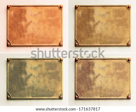 Four samples of old brass yellow, bronze, gold metal plate framed and nailed on white stone wall background