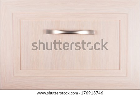 Comfortably furnished concept. Front of wooden cupboard empty drawer with polished satin chrome handle in light brown tone