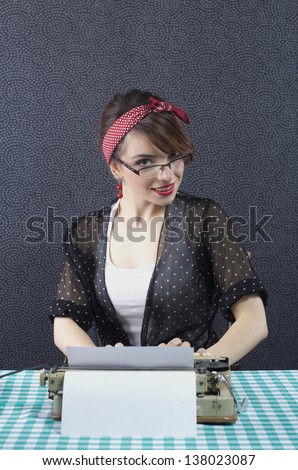 Sexy pin up secretary sitting at a desk and typing on typewriter
