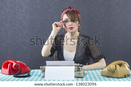 Sexy pin up secretary sitting at a desk and typing on typewriter