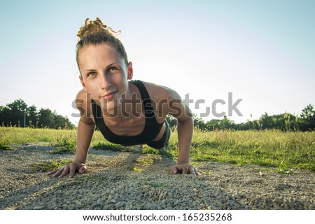 Push ups or press ups exercise by young woman