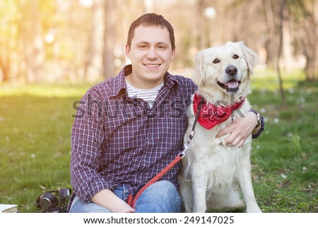 Smiling young man hugging a dog