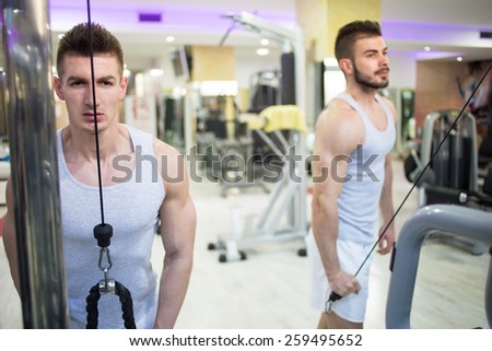 Two males are doing lateral pull-down weights