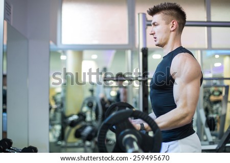Handsome Muscular Men Performing High Intensity Bicep Curls With Barbell