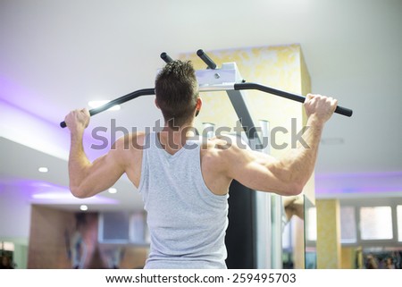 Muscular Men Doing Pull Ups (Chin-Ups) in the Gym
