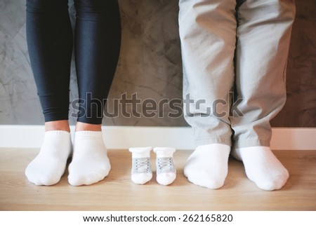 Mom and Dad\'s feet with socks for baby