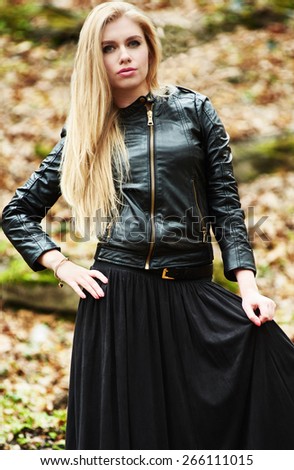 stylish blond woman in fashion black leather jacket and black skirt outdoor