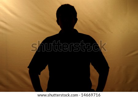 Silhouetted person against cloth sepia toned backdrop