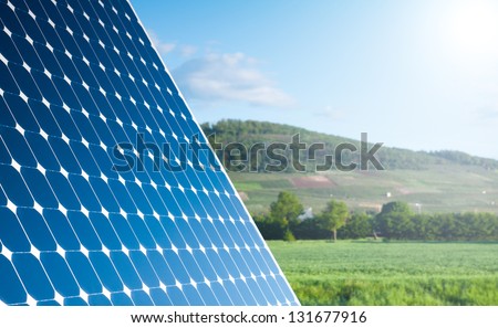 Solar Panel With Green Landscape Against The Blue Sky With Sunshine