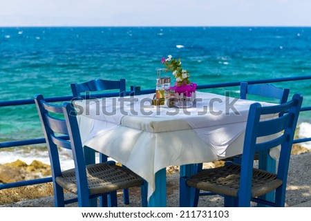 Table And Chairs In A Typical Tavern By The Sea At Rethymnon, Crete, Greece