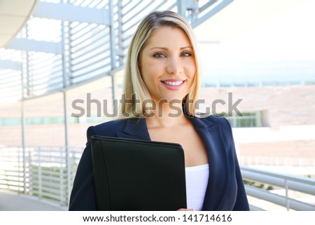 Business woman standing in business building with folder