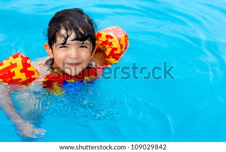 Cute little girl with hazel eyes and enjoy her time in the swimming pool