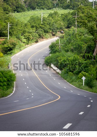 The road curves up the mountain. Line yellow and white road.