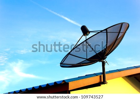 communication satellite dish over blue sky on roof
