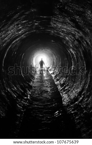 silhouette in a  communication tunnel. Light at End of Tunnel