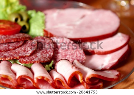 Cutting sausage and cured meat on a celebratory table.