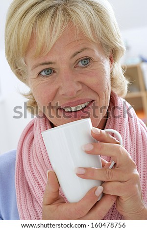 indoor picture of diseased but smilly senior woman with cup of tea