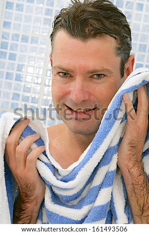 Body care- good looking middle age  man toweling  his face after shower