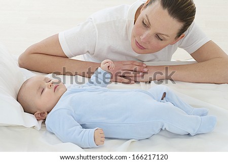 young mother with her baby lying in the bed