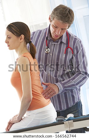 doctor and patient- medical visit for young woman focus on back disease