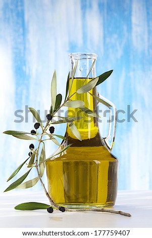 Olives, oil and a blossoming branch of an olive tree. Isolated on a blue background
