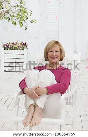 Senior Woman in pink vest  on the garden terrace