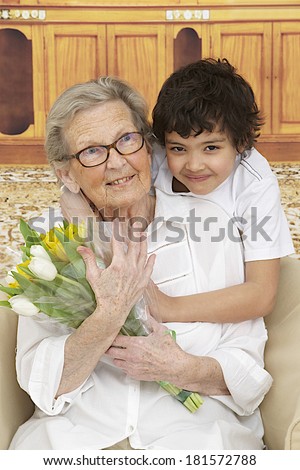 Little boy giving flowers to his grand mother  - grandmother's day
