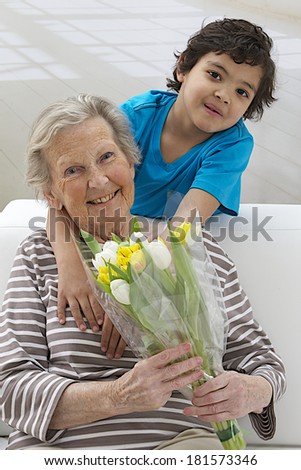 Little boy giving flowers to his grad mother  grandmother\'s day