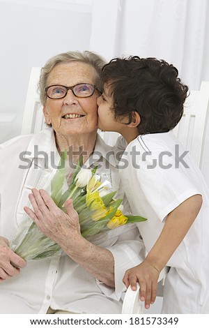 Little boy giving flowers to his grand mother  for, grandmother's day