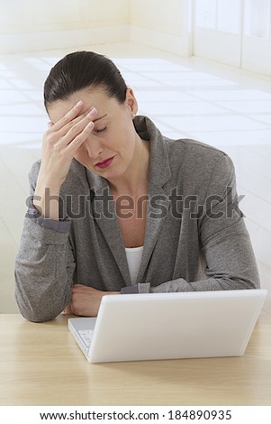 Businesswoman unhappy and depressed at work, thinking  about her problems